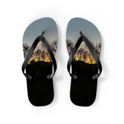 Black flip-flops with a sunset and silhouetted trees scene.