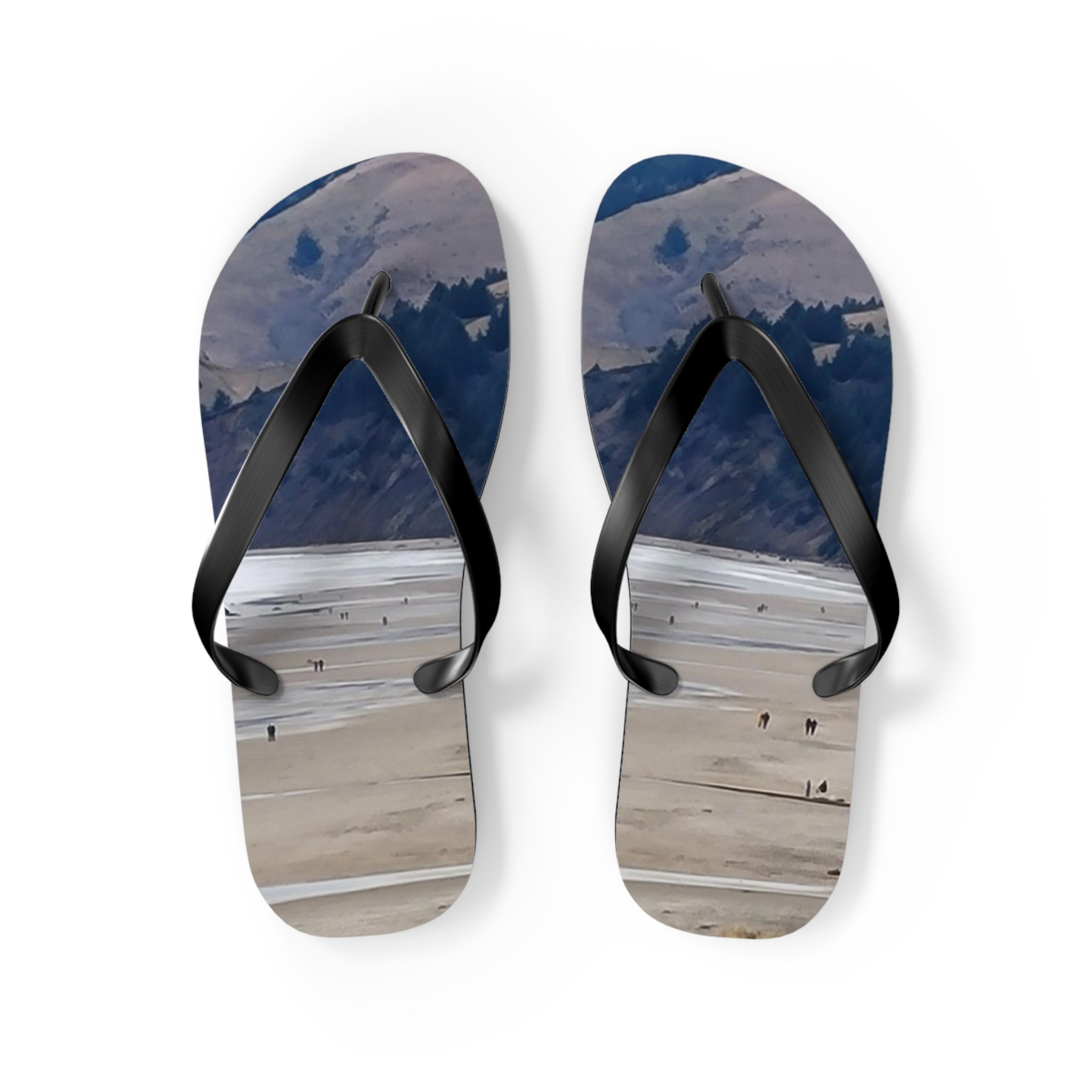 Flip-flops with a scenic landscape of people on a beach and mountains.