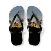 Flip-flops with a sunset landscape featuring trees and a hillside.