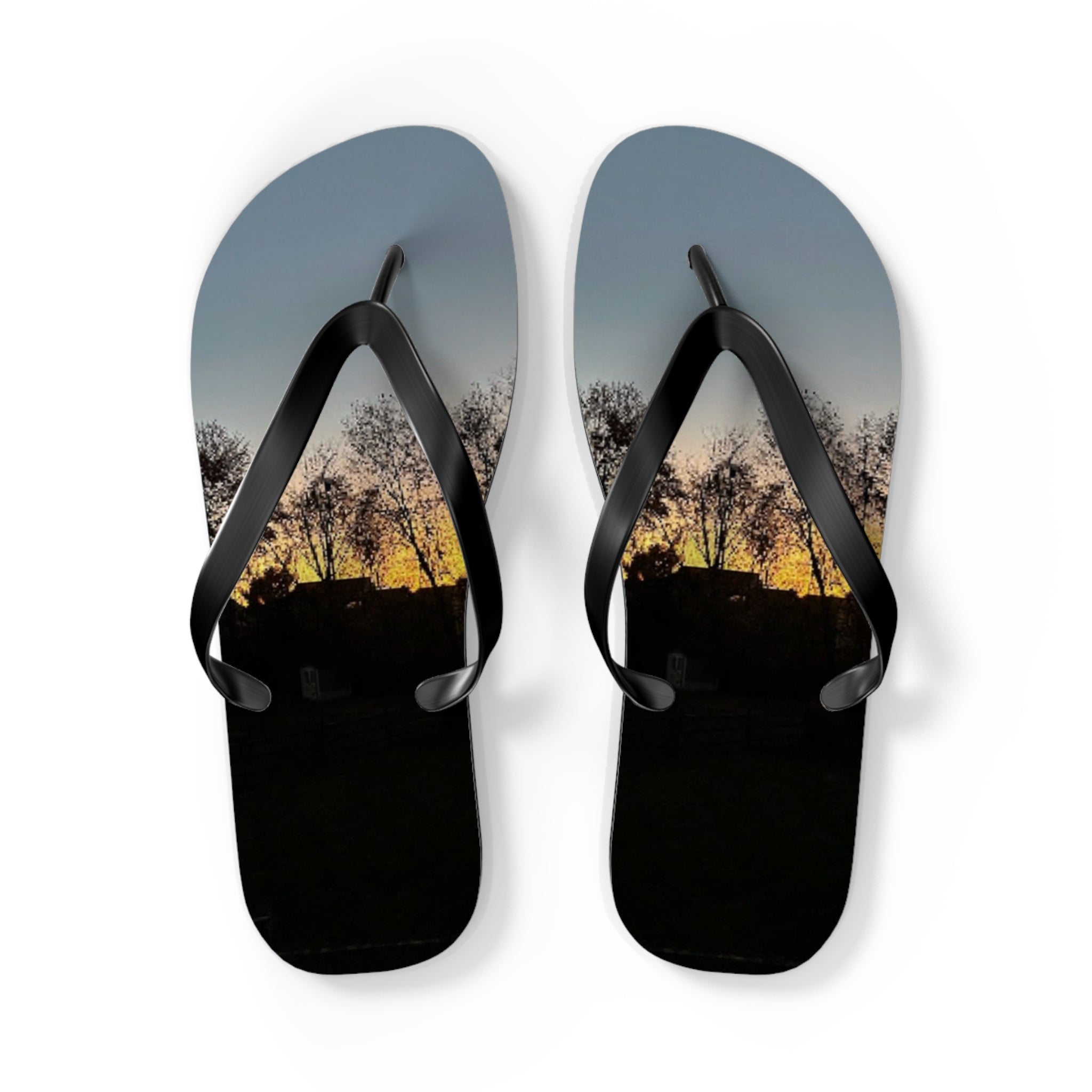 Flip-flops with a sunset landscape featuring trees and a hillside.
