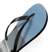 Black flip-flop with a beach scene on the sole against a white background.
