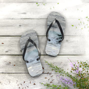 Flip-flops with a wave design on a weathered wooden surface.