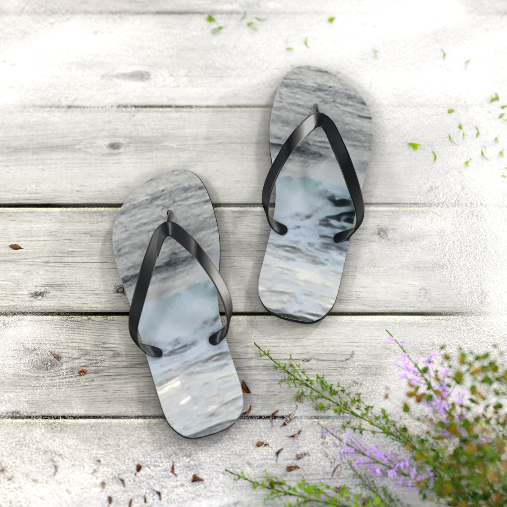 Flip-flops with a wave design on a weathered wooden surface.