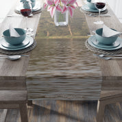 Table runner with lake reflection and pink lilies in background.