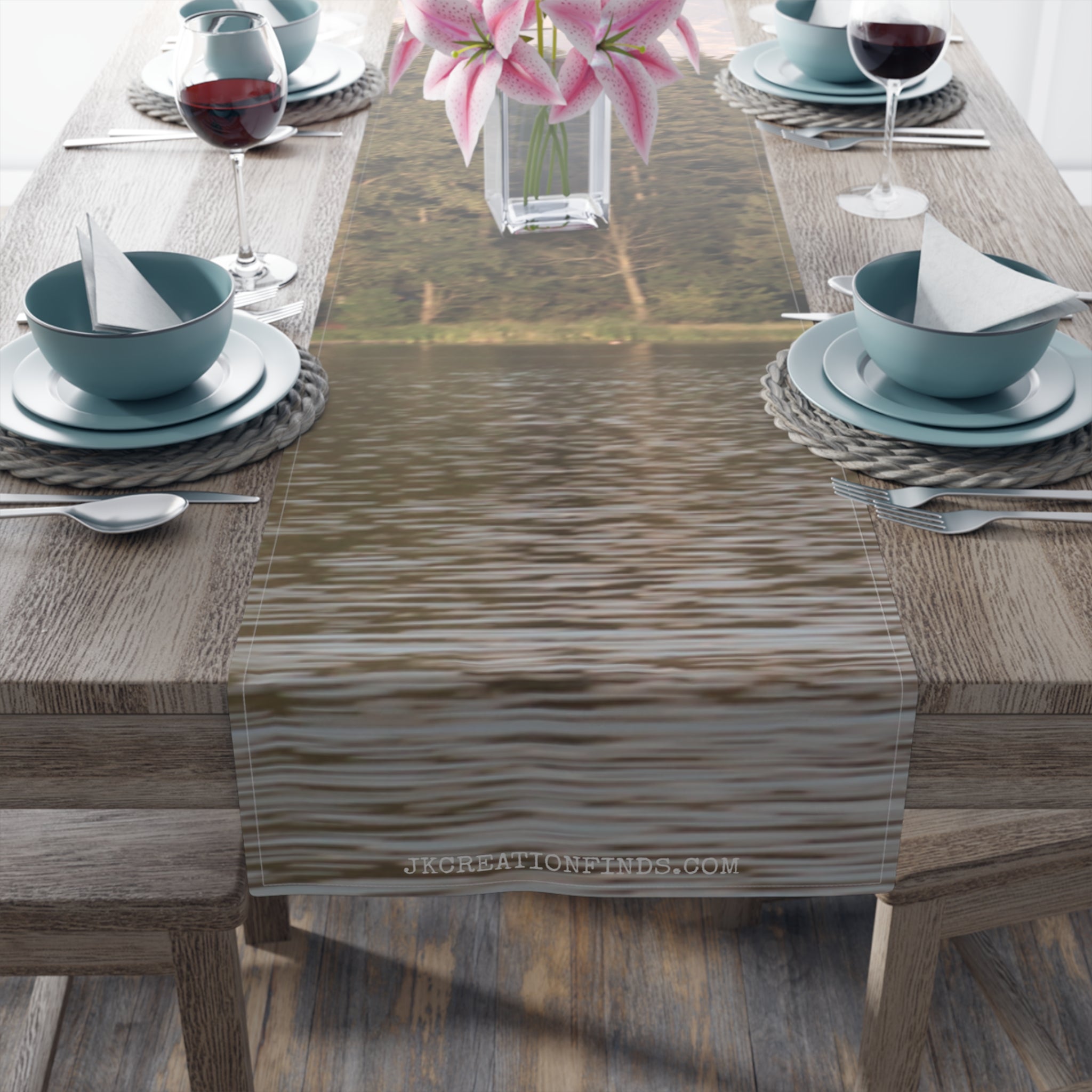 Table runner with lake reflection and pink lilies in background.