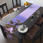 Table runner with lavender print on a dining table with plates and glasses.