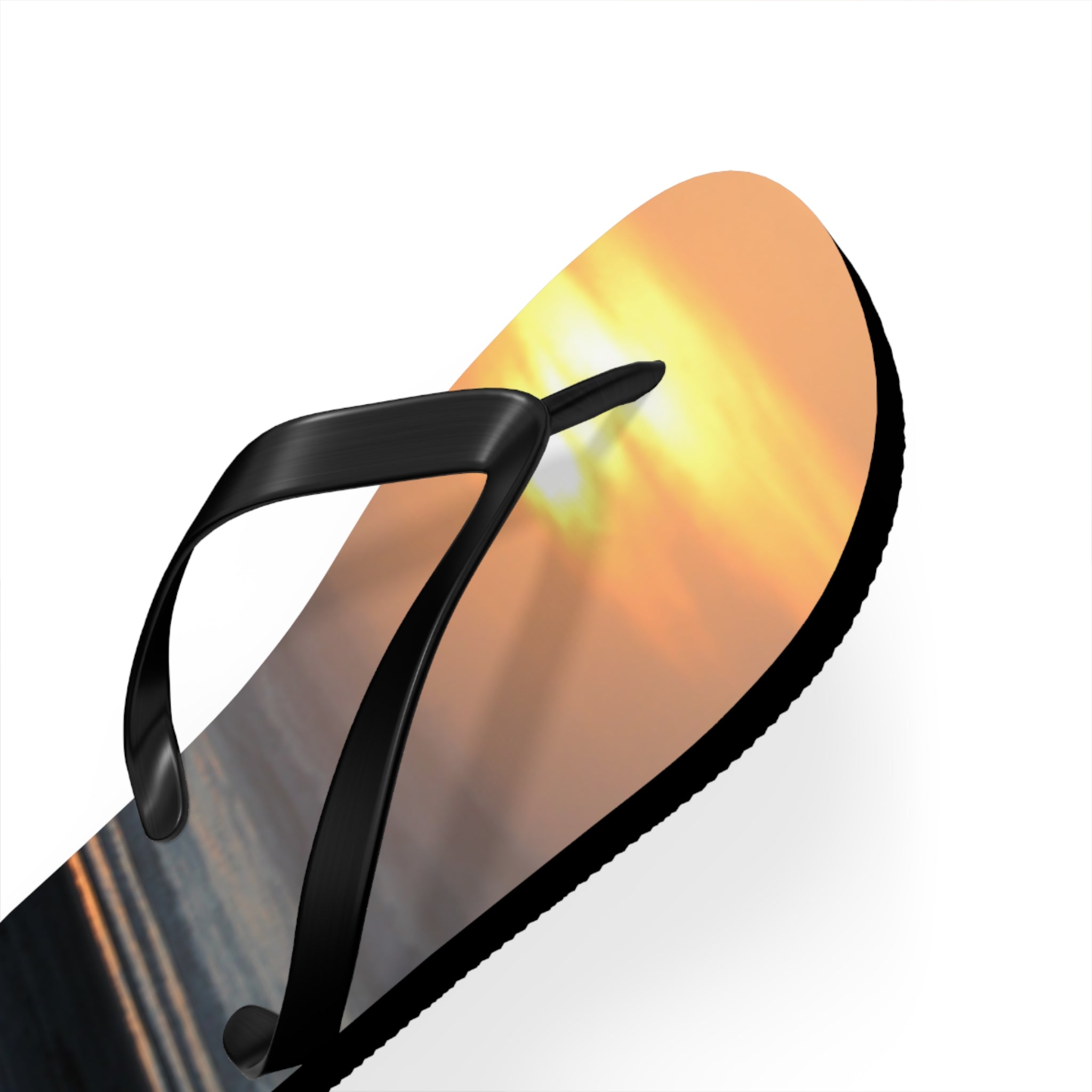 Black flip-flop with a sunset beach scene design on the sole.