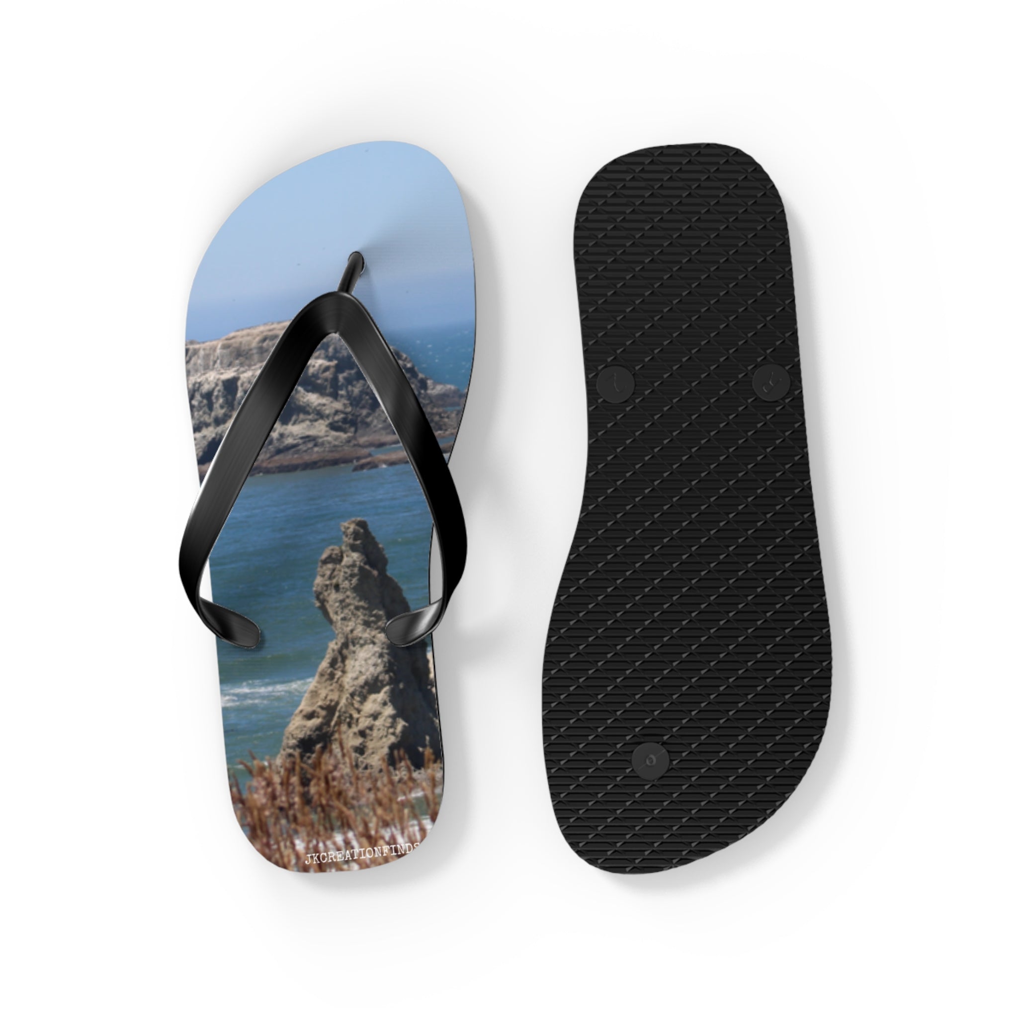 Flip flops featuring a scenic coastal rock formation against a blue sky.