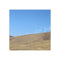 Wind turbines on a rolling, dry hillside under a clear blue sky.