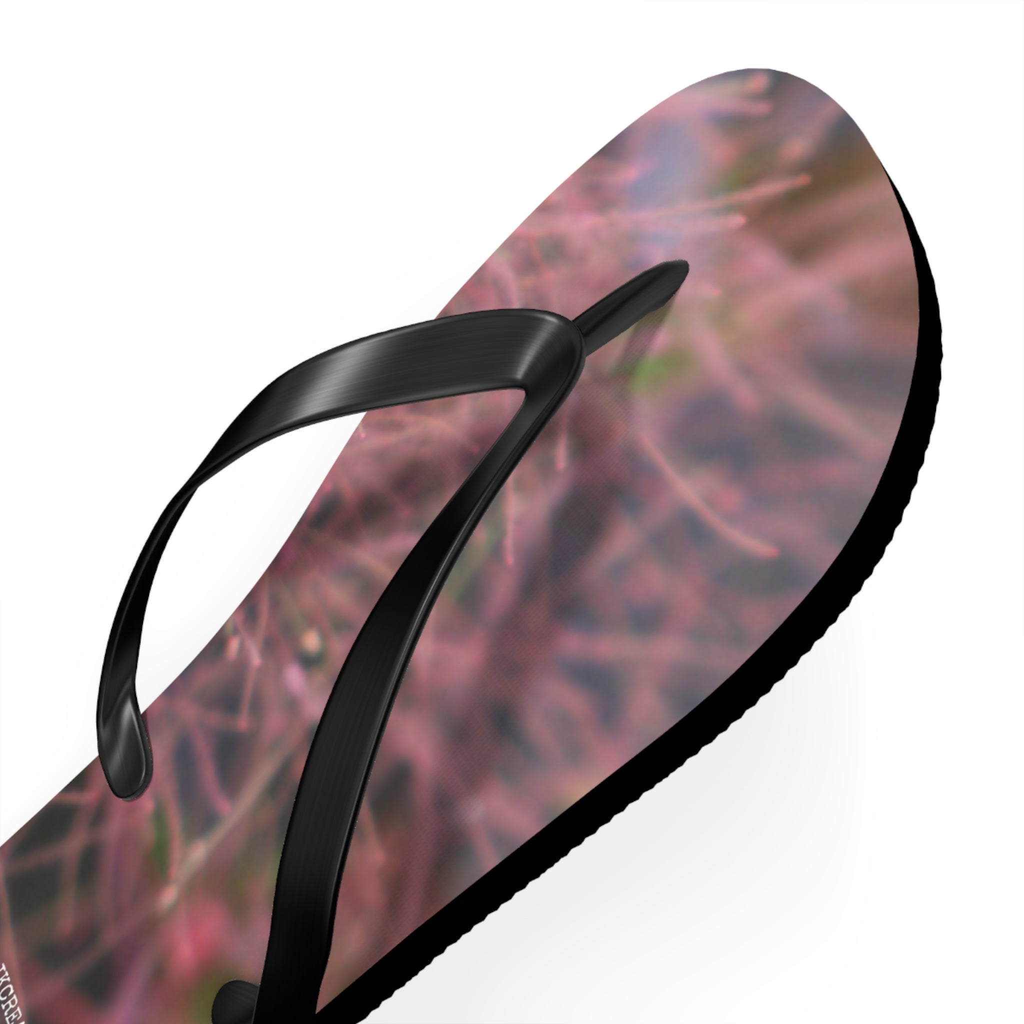 Black flip-flop with abstract pink and purple floral sole pattern.