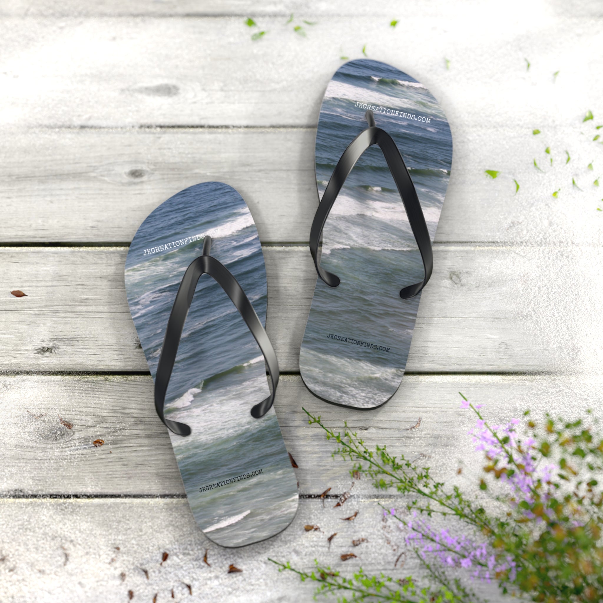Two flip-flops with ocean wave pattern on weathered wood surface.