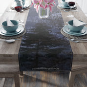 Dark forest scene printed on a fabric table runner with white text.
