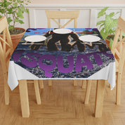 Tablecloth with purple "Squad" text and bear graphic on a wooden table.