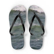 Black flip-flops on a background of ocean waves.