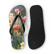Flip-flops with pink tulips and yellow daffodils on the left, black sole on the right.