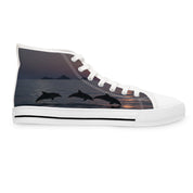 High-top sneaker with three leaping dolphins silhouette on sunset ocean background.