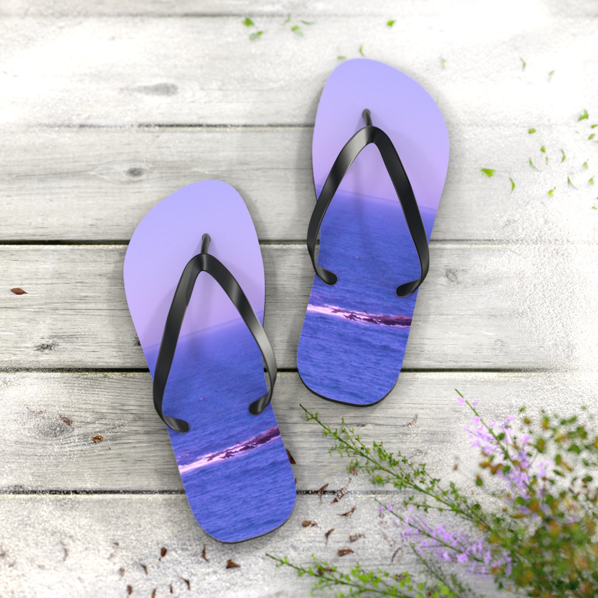 Purple flip-flops with ocean wave print on a wooden surface.