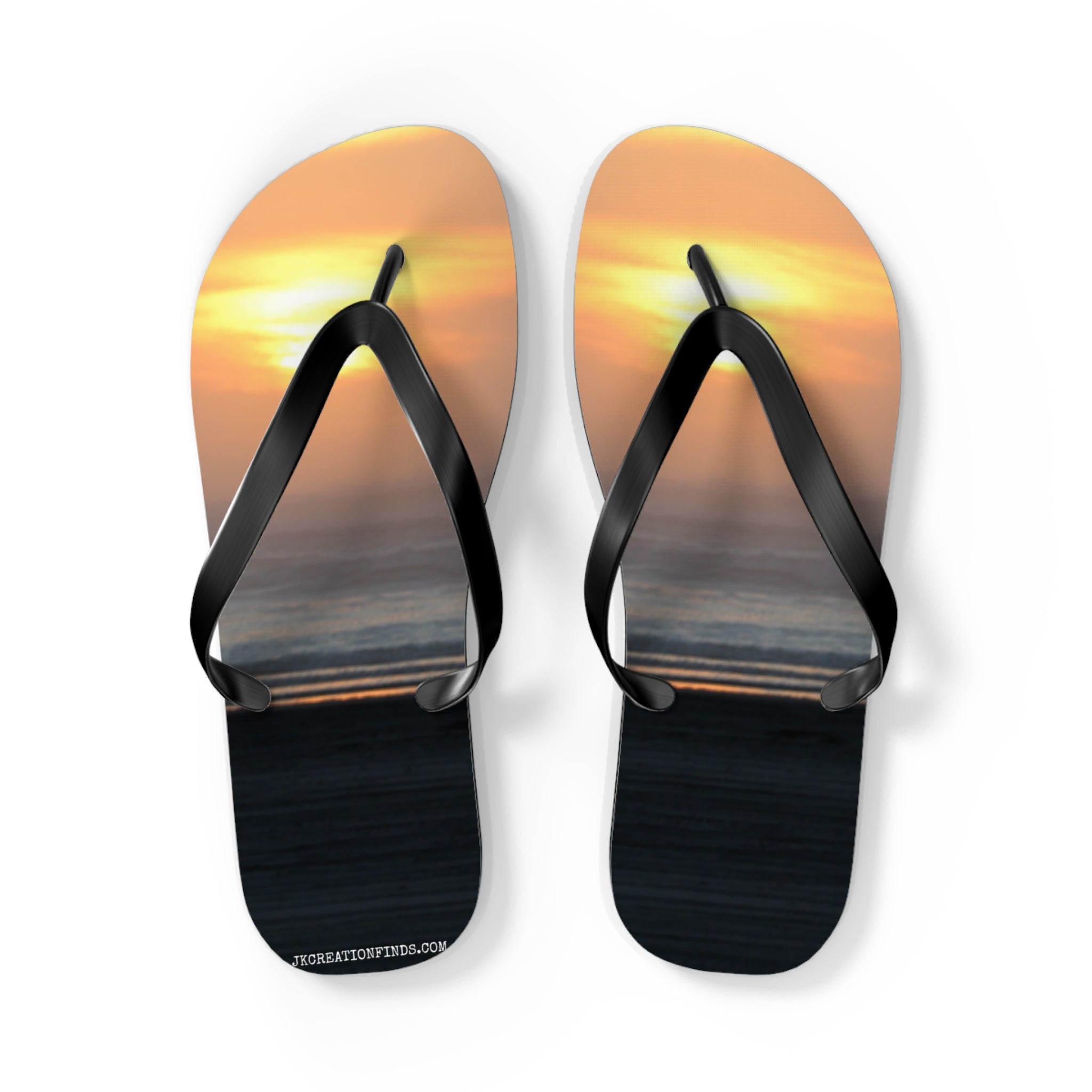 Black flip-flops with a sunset over the ocean scene on the soles.