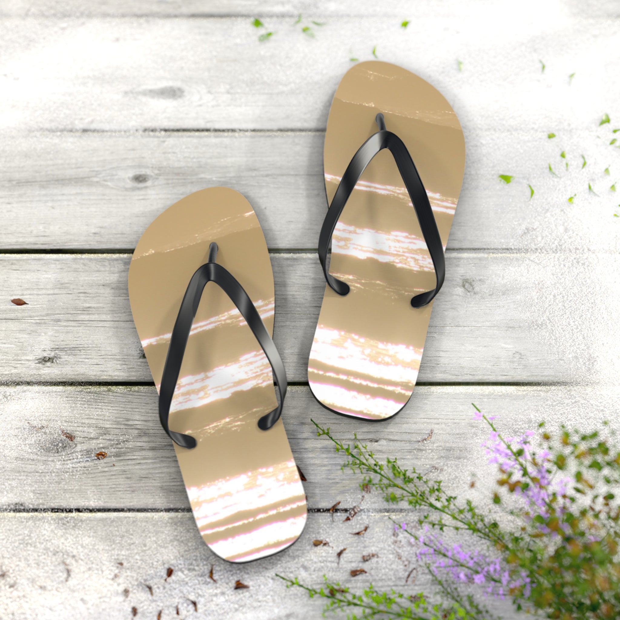 Tan flip-flops with white striped accents on a weathered wooden surface.