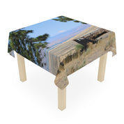Tablecloth with landscape scene featuring pine trees, mountains, and a cloudy sky.