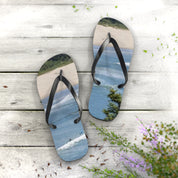 Flip-flops with a beach scene and surfers on white wooden planks.