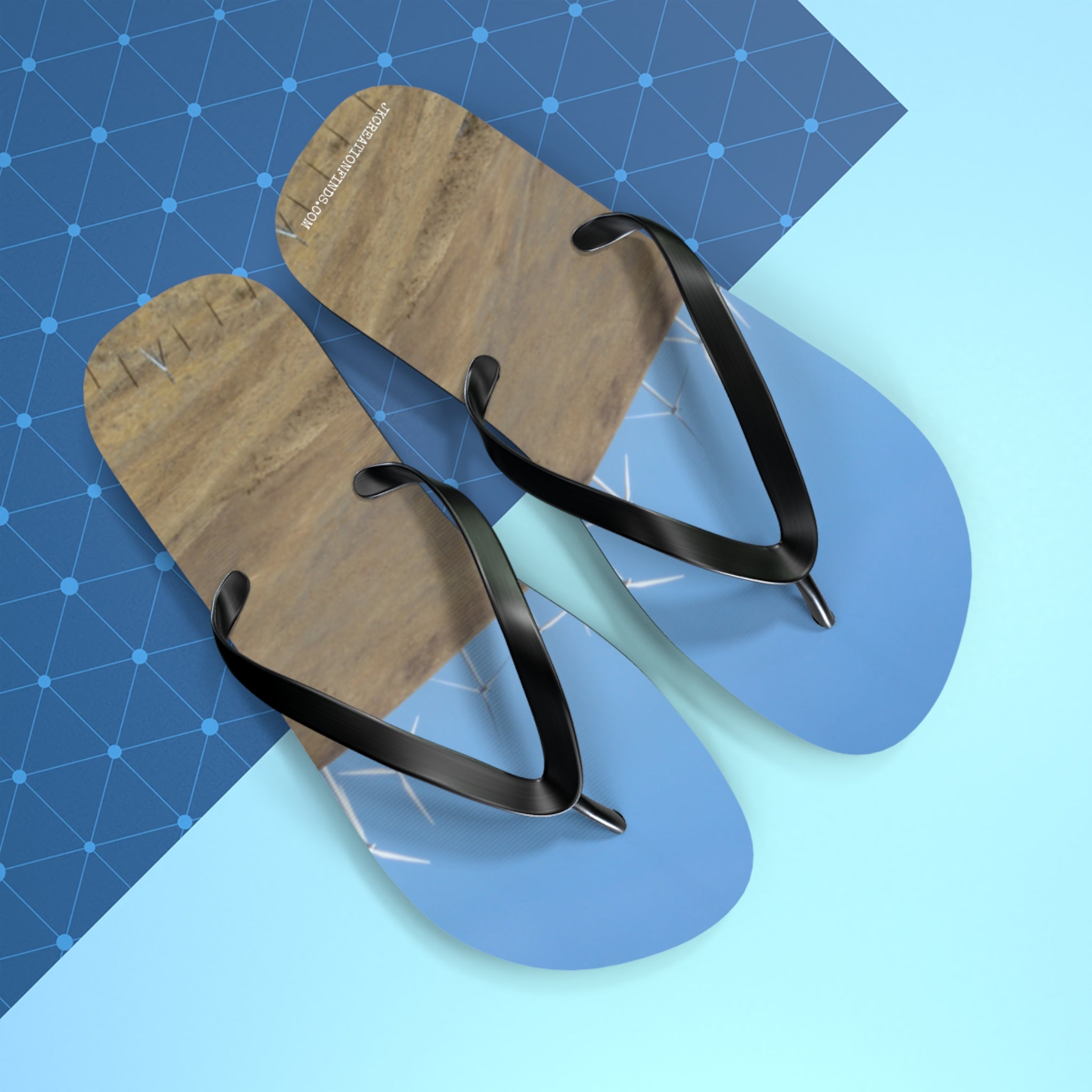 Flip-flops with a landscape design on a blue geometric background.