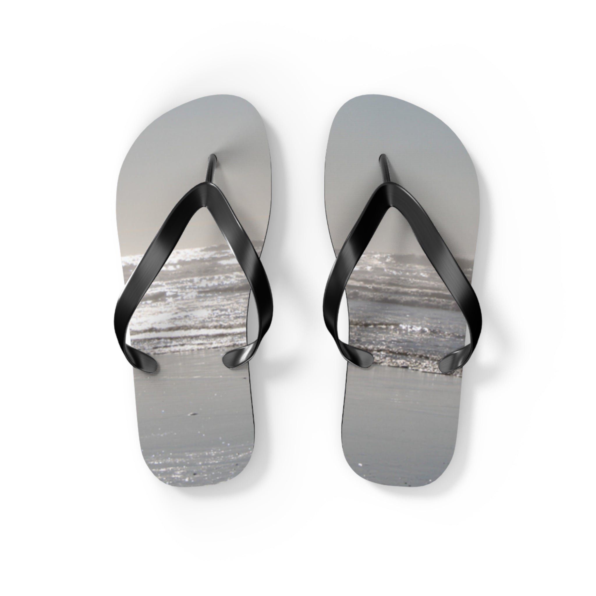 Flip-flops with a beach and ocean wave scene printed on the soles.