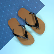 Brown flip-flops with black straps on a blue and light blue background.