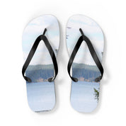 Flip-flops with a serene lake and forest landscape printed on the soles.