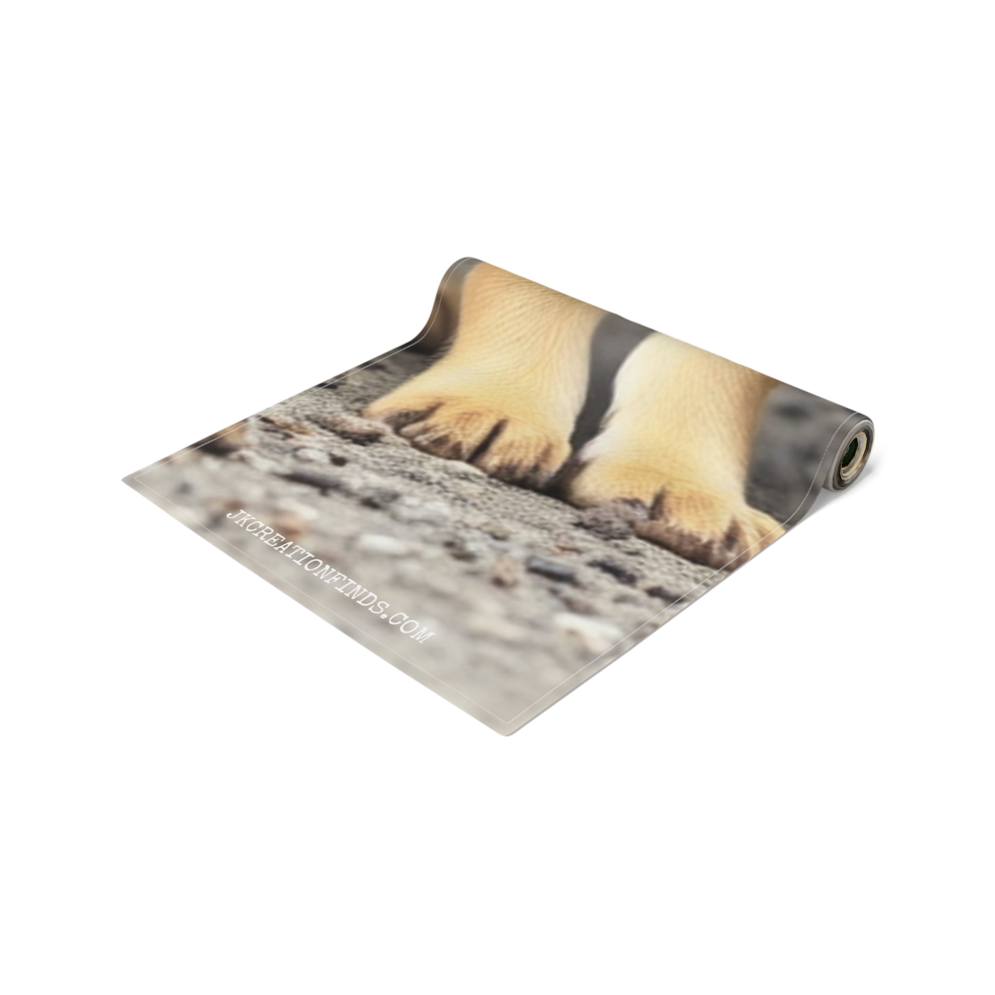 Rolled up yoga mat with puppy paws on a concrete surface.