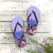 Purple flip-flops with a tropical island scene on the soles, resting on a wooden surface.