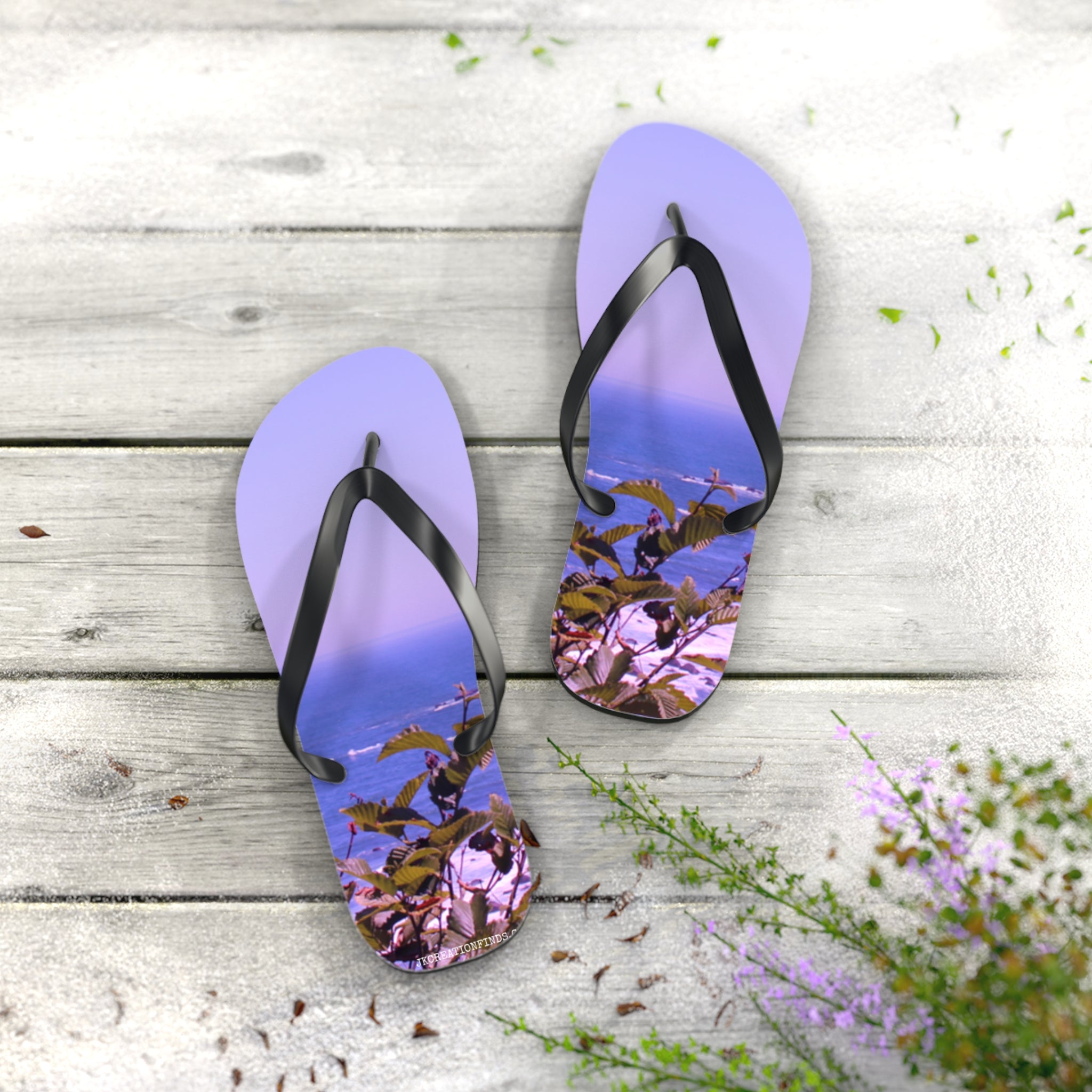 Purple flip-flops with a tropical island scene on the soles, resting on a wooden surface.