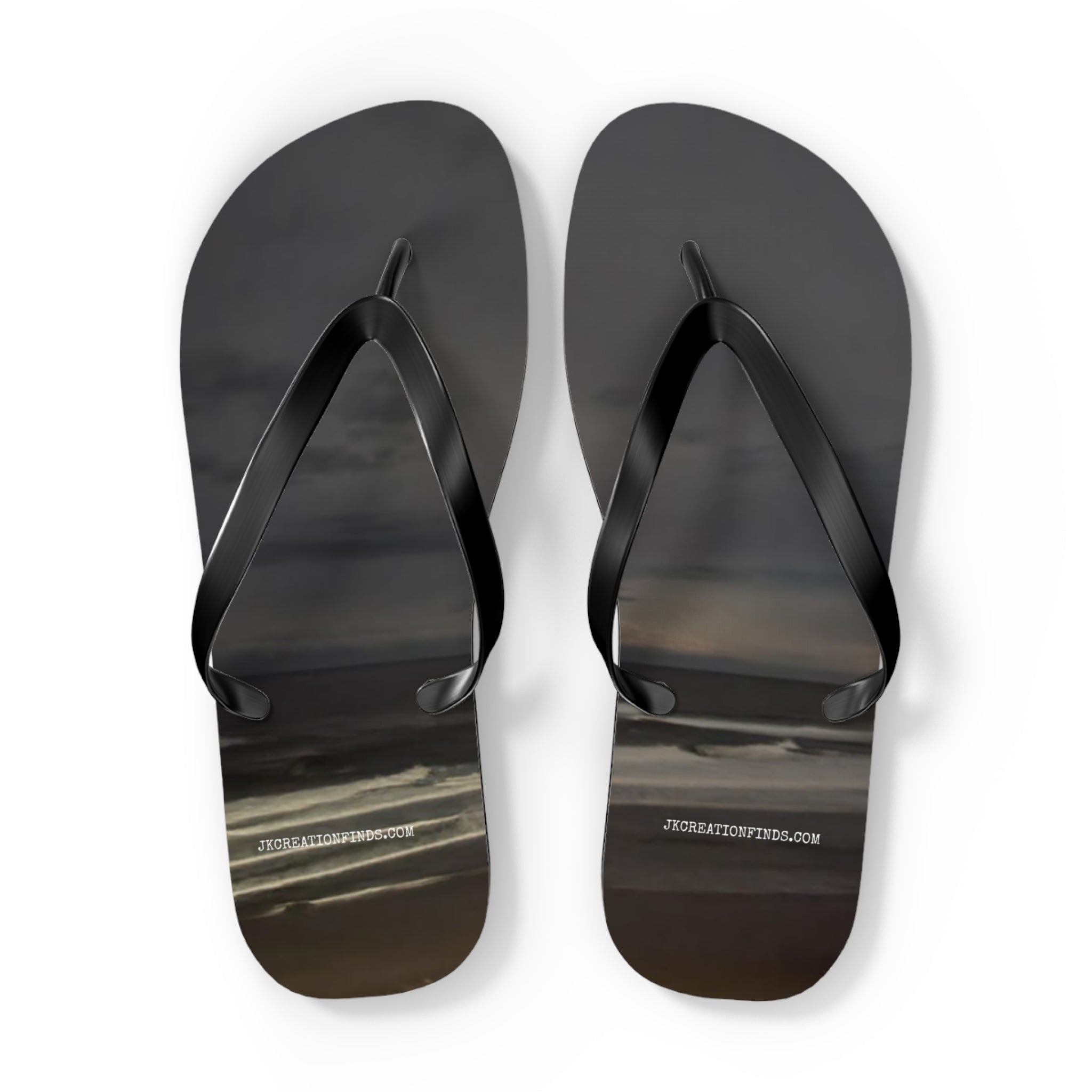 Black flip-flops with a cloudy sky design and website URL.