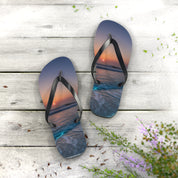 Flip flops with a sunset beach scene on a wooden deck.