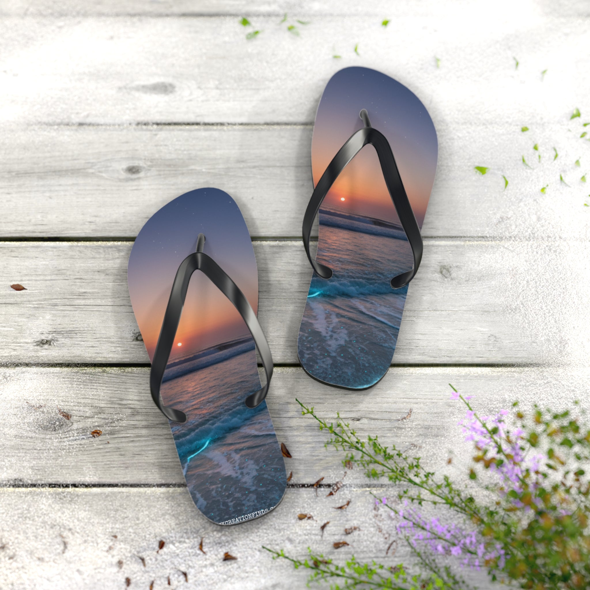 Flip flops with a sunset beach scene on a wooden deck.