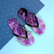 Purple floral flip-flops on a blue and white patterned background.