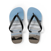 Flip-flops with a beach scene featuring two figures and ocean waves.