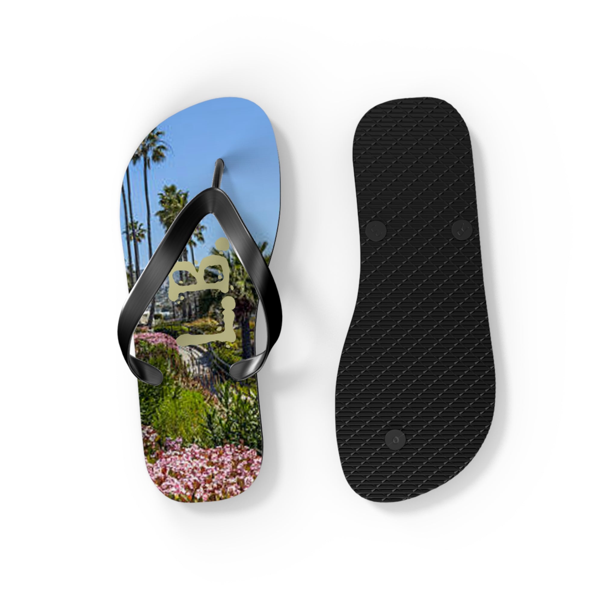Black flip-flops with a tropical beach scene on one sole.