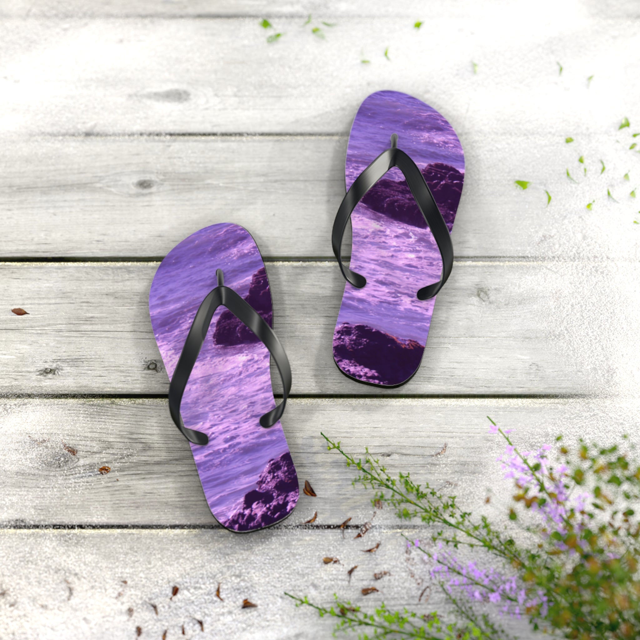 Purple abstract ocean pattern flip-flops on wooden deck.