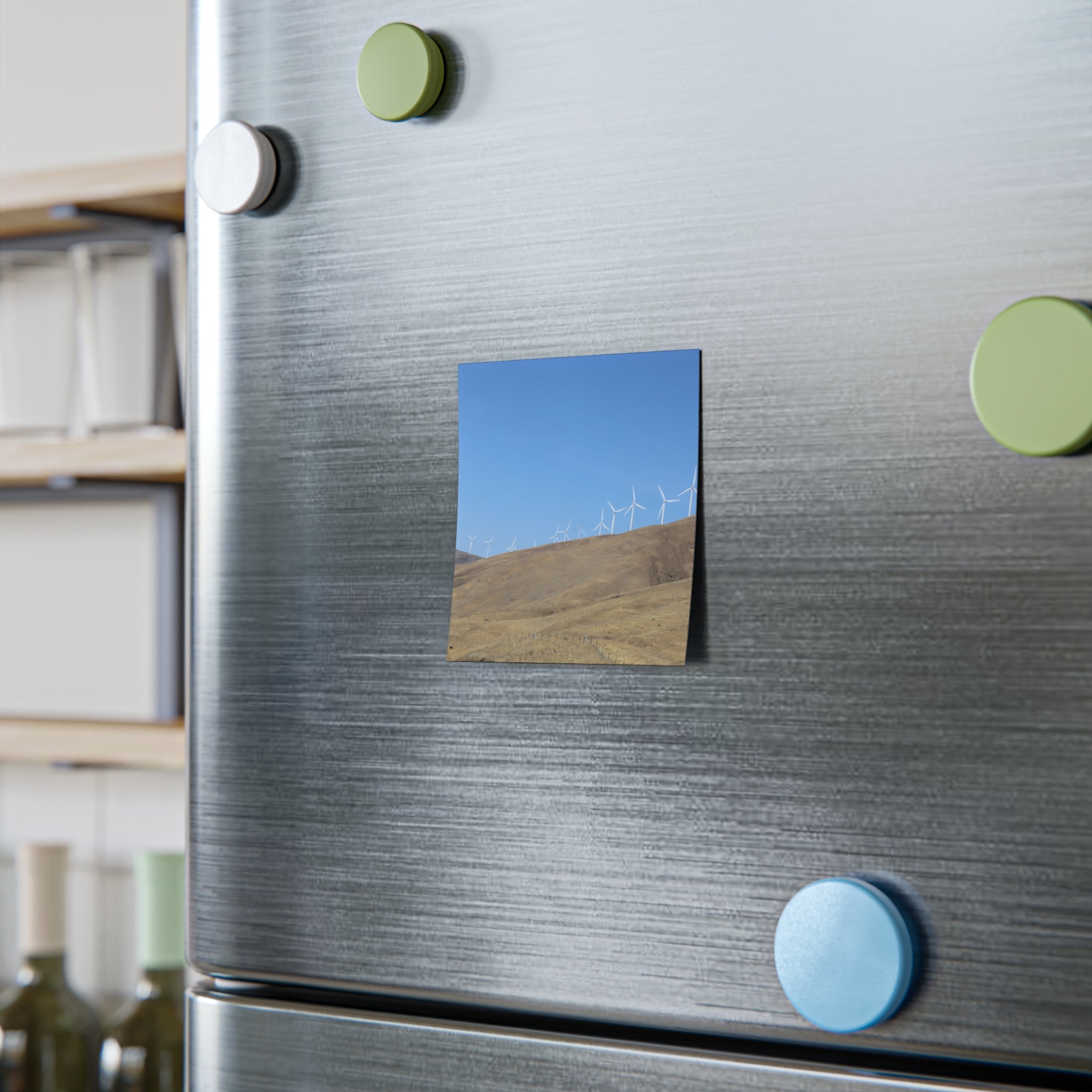 Square magnet with wind turbines on a grassy hill under a blue sky.