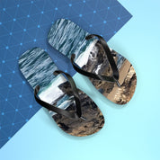 Flip-flops with a beach and ocean wave design on blue background.