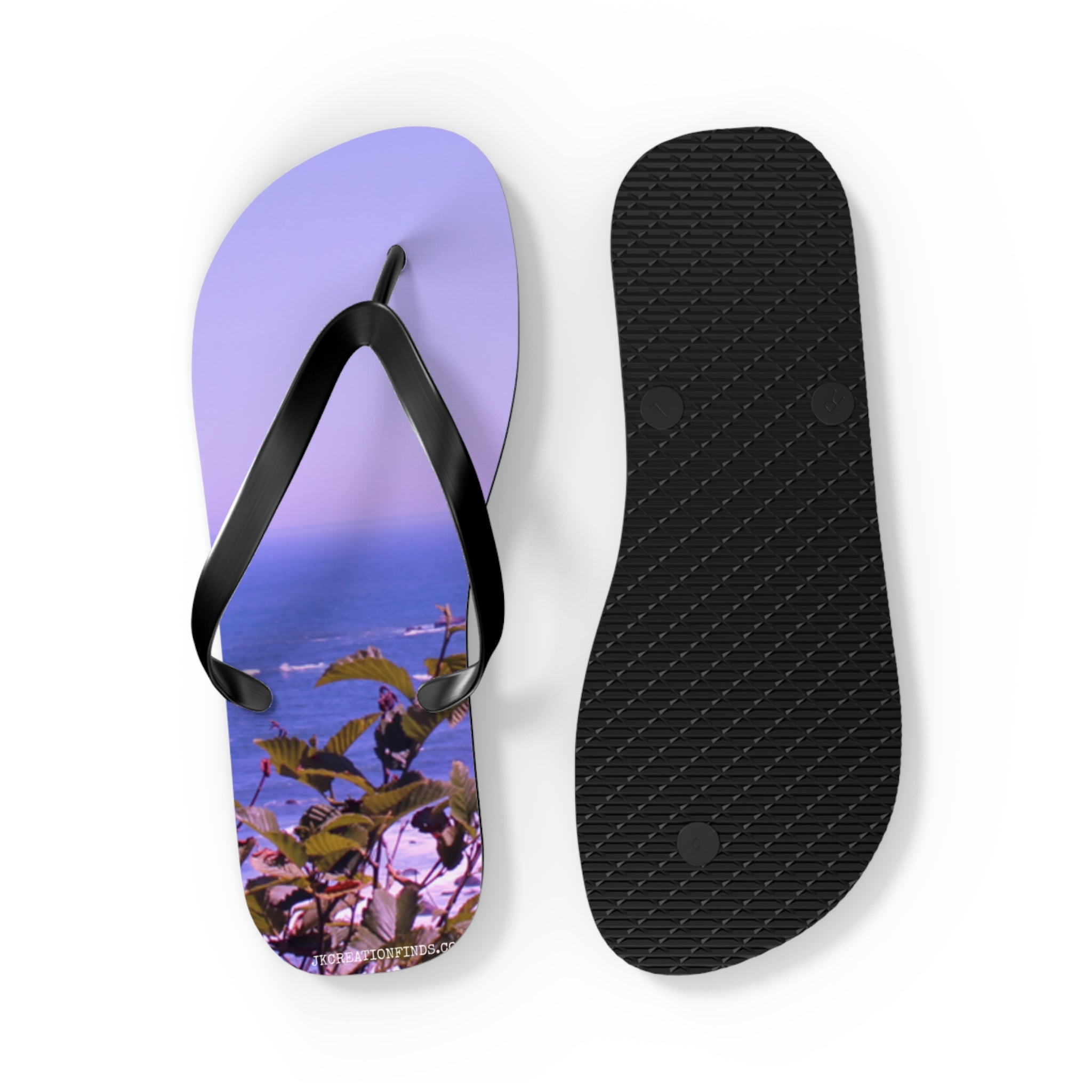 Flip flops with a tropical beach scene and leaves on one sole.