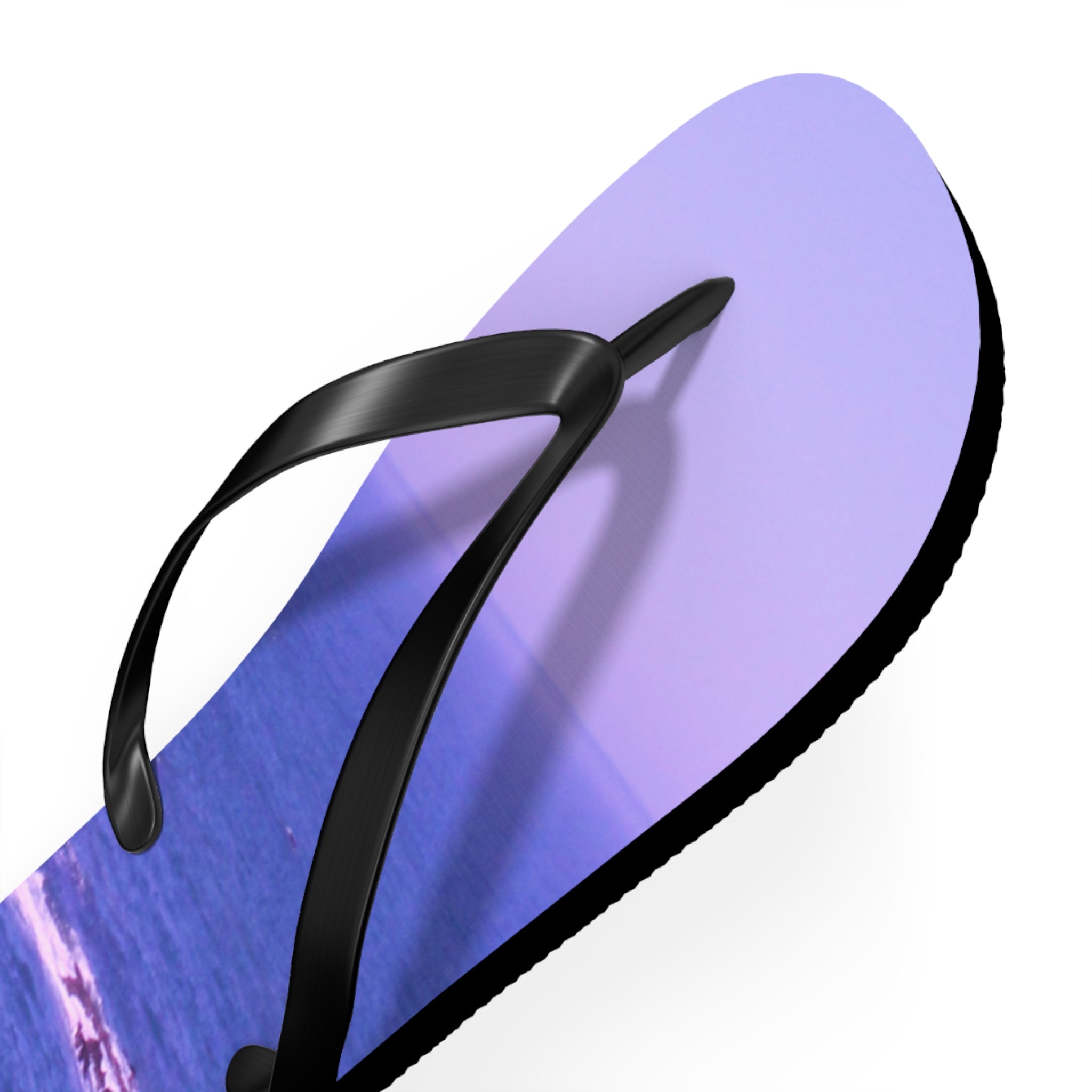 Purple flip-flop with a beach scene on the sole, against a white background.