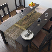Table runner with forest and lake scene, set on a dining table.