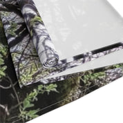 Rolled fabric with blurred forest camouflage pattern on white background.