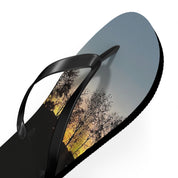 Black flip-flop with sunset landscape on the sole.