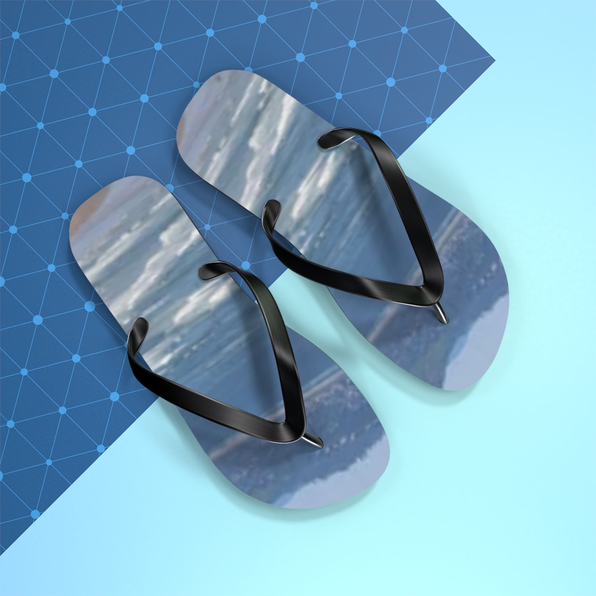 Black flip-flops with a watery, abstract blue and gray pattern.
