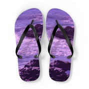 Purple flip-flops with a rocky ocean wave design.