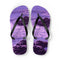 Purple flip-flops with a rocky ocean wave design.