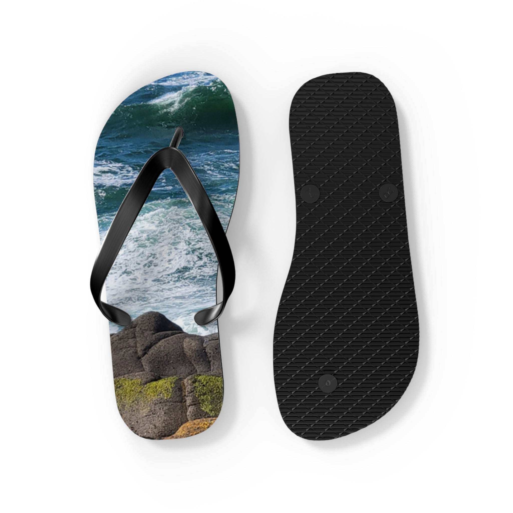 Flip-flops with ocean waves and rocks design on one, black sole on the other.